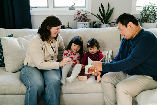 happy family of four reading on the sofa