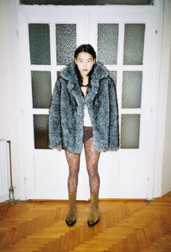 Model Poses in Stylish Outfit Near a Glass Door