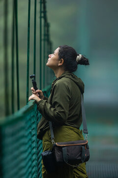Content creator recording with a mini camera on a suspension bridge