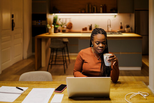 Woman working remotely with laptop at home
