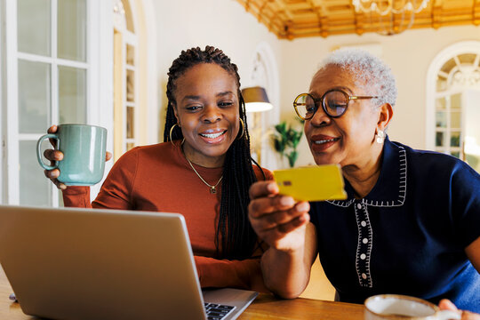 Woman and daughter making online purchases with credit card at home