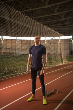 Sportsman standing on track near starting blocks
