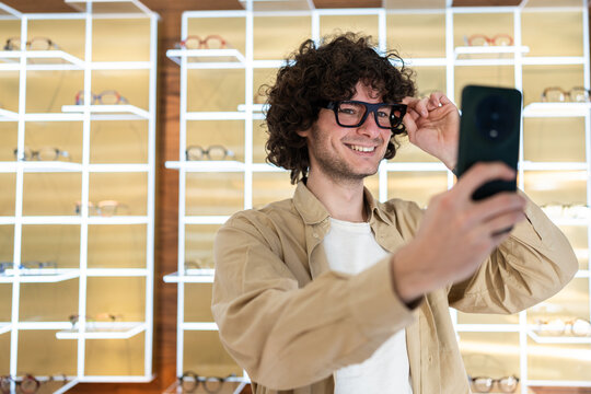 Man smiling trying on eyewear taking selfie