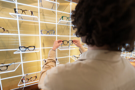 Person choosing new glasses frames in optical shop