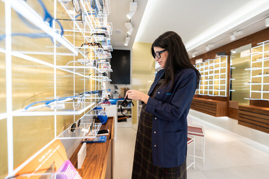 Pregnant optometrist working in modern optical store