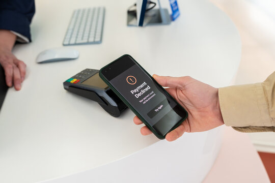 Hand holding smartphone with payment declined message