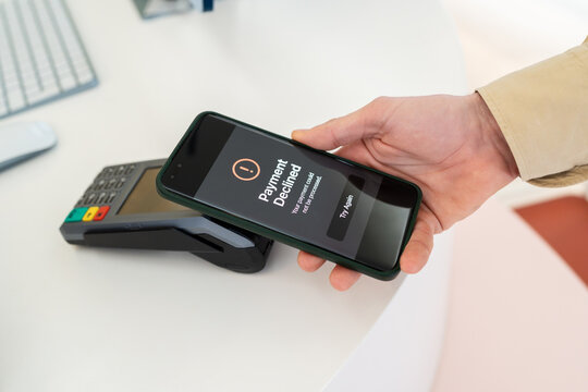 Hand holding phone with Payment Declined message