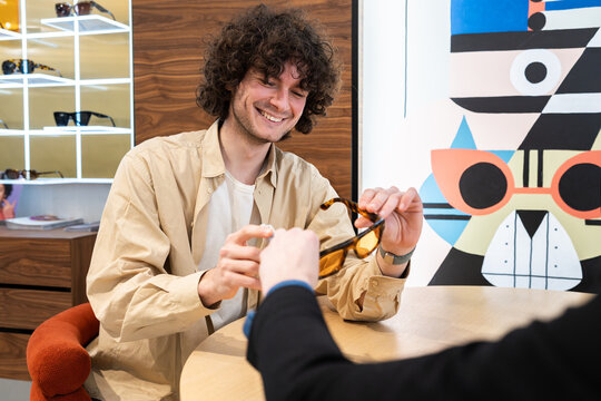 Smiling customer trying on eyewear in optical shop