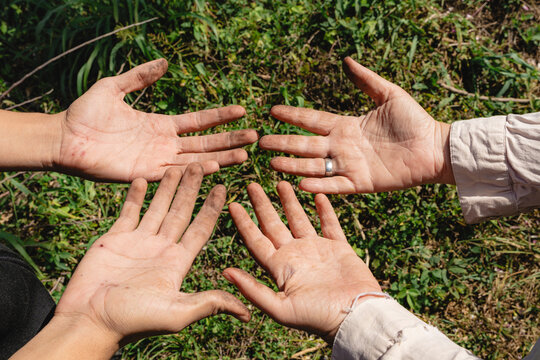 People showing dirty hands representing manual labor and teamwork