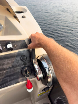 Hand on boat throttle at lake 