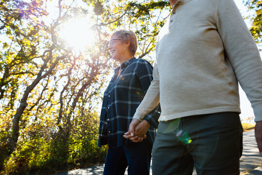 Candid moment: an older couple holding hands on a sunny walk