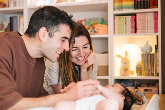 Parents smiling at baby during changing time at home