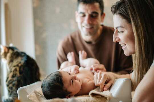 Parents bonding with baby during changing at home