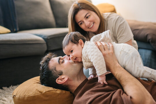 Parents playing on floor with baby at home