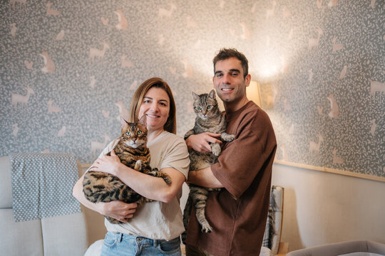 Parents and partners holding cats at home nursery