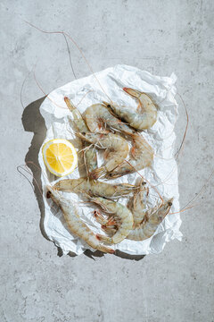 Raw shrimp with lemon on parchment paper