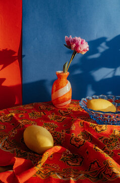 Bright still life with vase flowers and fruit on table
