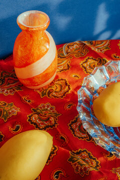 Bright colors and shapes on a table with fruit and a vase