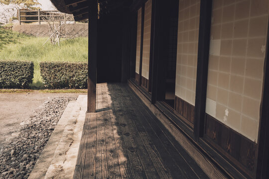 伝統的な日本家屋の古びた木製縁側と障子戸が織りなす光と影の風景,
