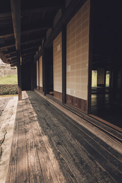 伝統的な日本家屋の古びた木製縁側と障子戸が織りなす光と影の風景,
