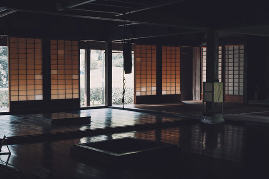 伝統的な日本家屋にある囲炉裏と光差す障子戸の室内風景,
