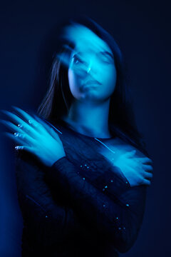 Woman with blue light effect in a dark setting during a studio s