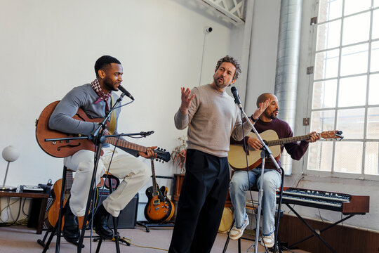 Musicians rehearsing together in a bright studio