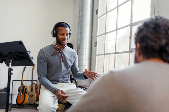 Singer in headphones practicing a song in music studio