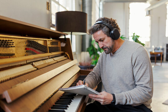 Composer writing music at piano