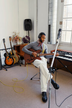 Musician playing electric guitar in music studio