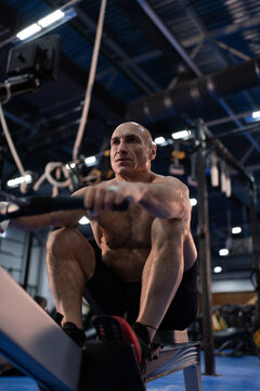 Sportsman exercising on rowing machine during workout
