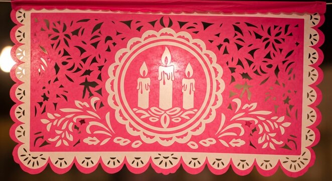 Papel picado rosa mexicano con dise&ntilde;o de velas y flores, decoraci&oacute;n festiva tradicional para Cinco de Mayo, artesan&iacute;a de papel calado para eventos y celebraciones culturales.