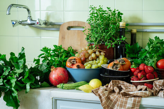 Assorted fruits, vegetables, and herbs on kitchen counter