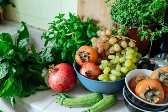 Fresh fruits and herbs on kitchen counter near sink 