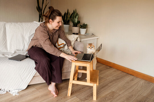A woman working at home with her cat.