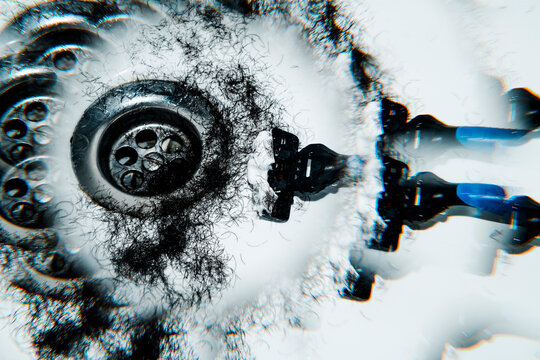 hair and a shaving razor near a drain, in a kaleidoscopic image