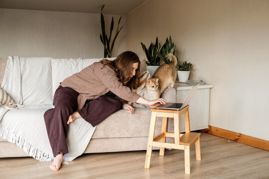 A woman having fun with her cat at home.