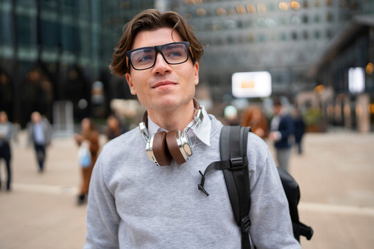 Young man stands in city square
