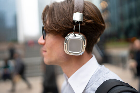 Young man listens to music outdoors
