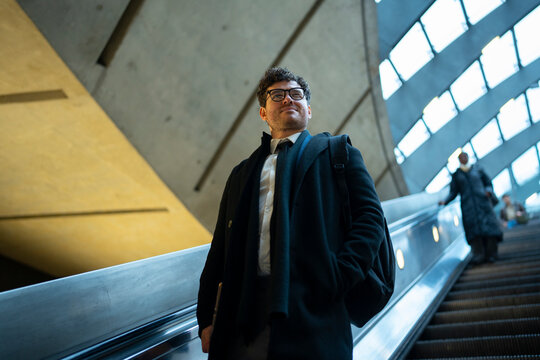 Businessman Riding Escalator in Metro Station