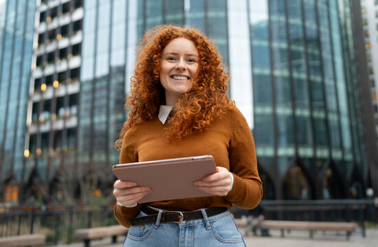 Woman with tablet in city square
