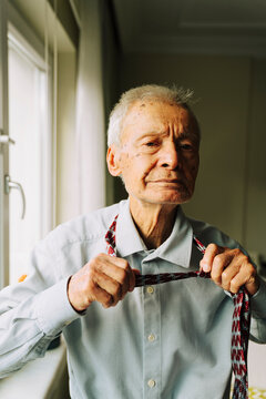 Senior man loosening his tie