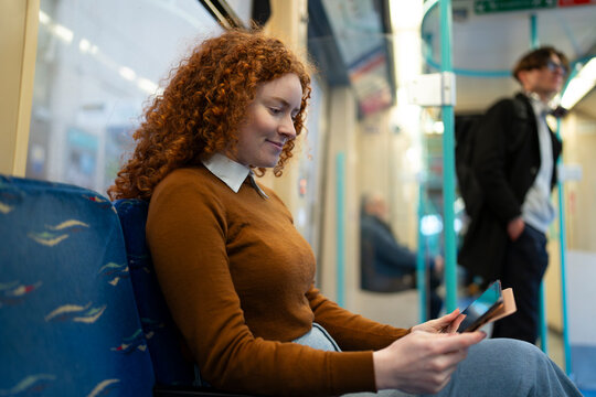 Woman using phone on train ride
