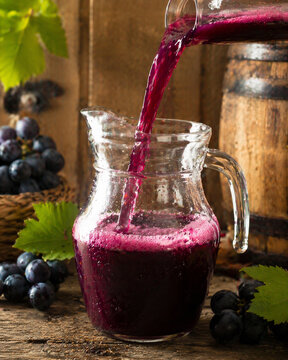 Suco de uva fresco sendo servido em jarra de vidro em vin&iacute;cola