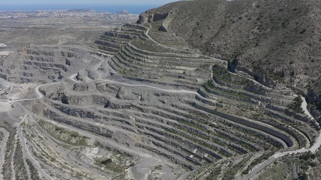 Aerial view of a cement quarry with special vehicles assisting in rock extraction in Spain.
