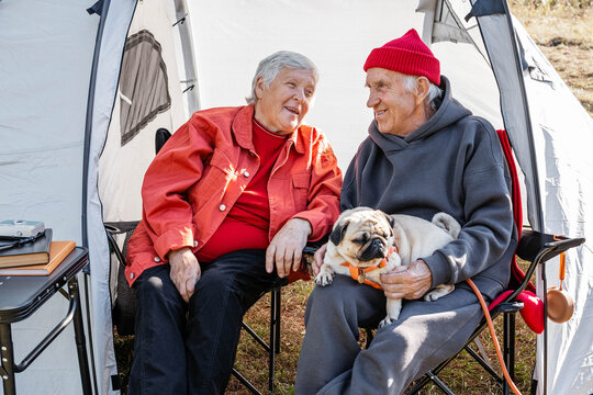 A man and a woman in a tent with a dog