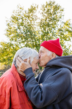 A man kisses a woman on the forehead