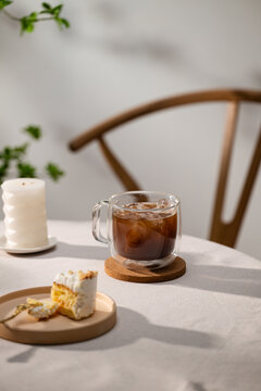 Iced coffee in a glass with cake on a table, a relaxing moment