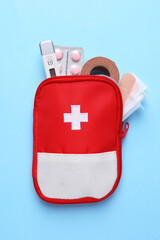 First aid kit on light blue background, top view