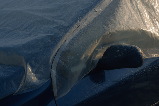 car covered with plastic sheet in winter